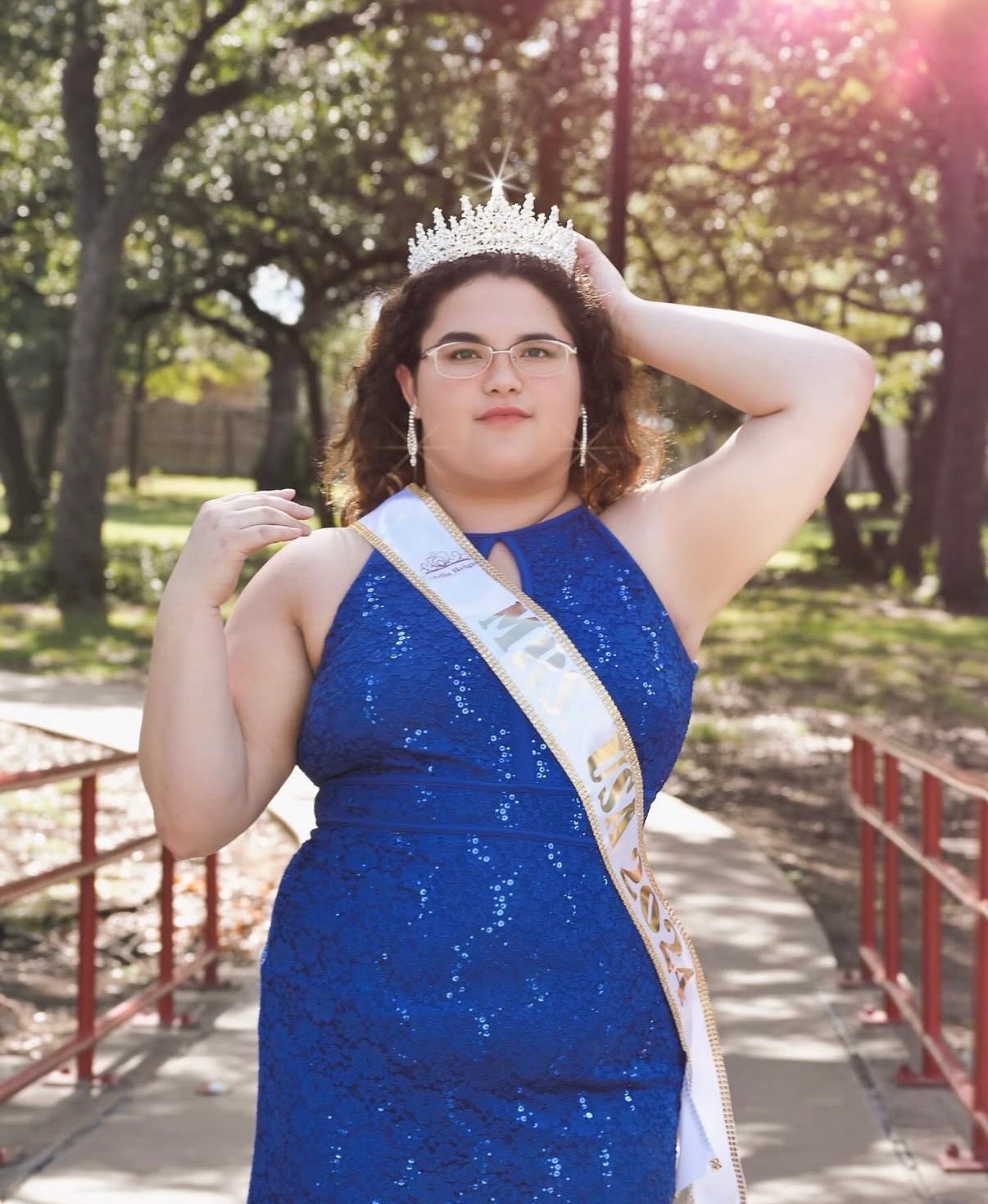 Dania Morales, a crowned Stella Reign titleholder wearing her sash in the park